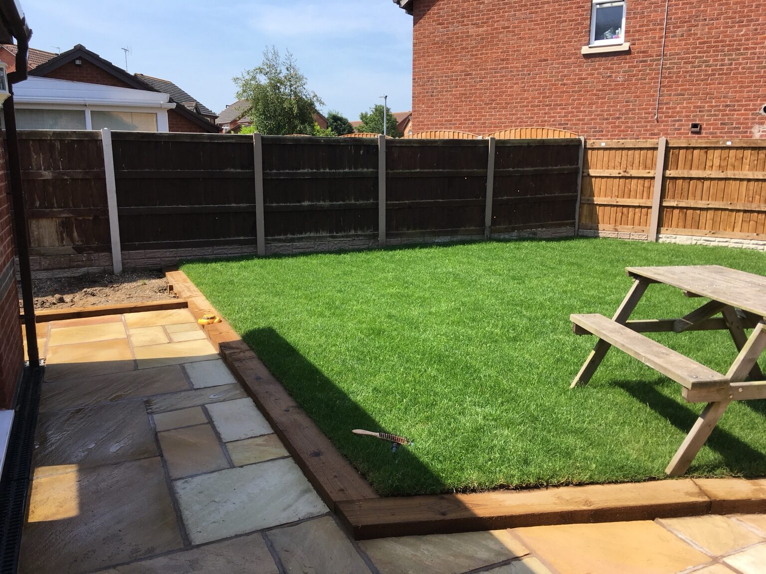 Finished landscaped garden with sandstone patio and new lawn