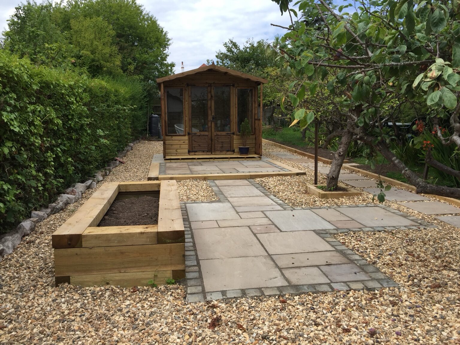 Finished low-maintenance garden with paved paths and summerhouse