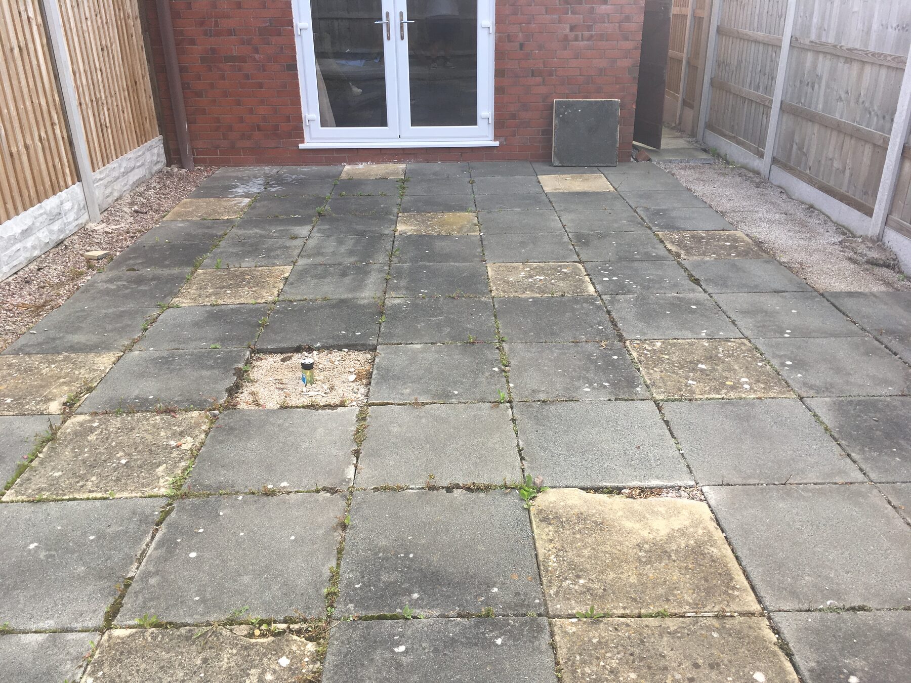 Old mismatched slab patio before replacement
